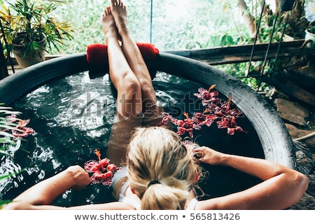 woman-relaxing-round-outdoor-bath-450w-565813426